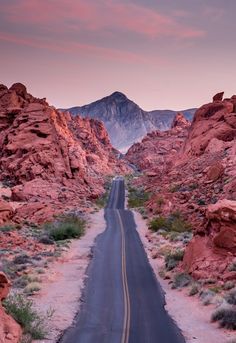 an empty road in the middle of some mountains