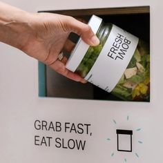 a person is holding a jar in front of a food dispenser that says grab fast, eat slow