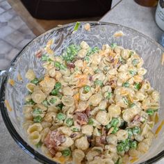 a glass bowl filled with pasta and peas