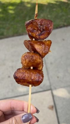 a person is holding some food on a stick