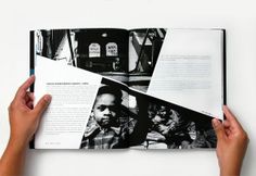 two hands holding an open book with black and white photos