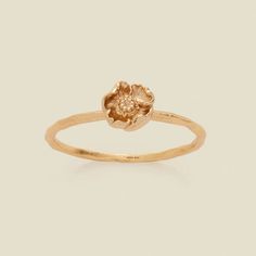 a gold ring with a flower on the front and center, set against a white background