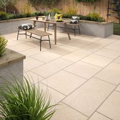 an outdoor patio with table, chairs and plants