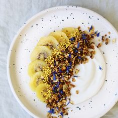 a white plate topped with bananas and granola