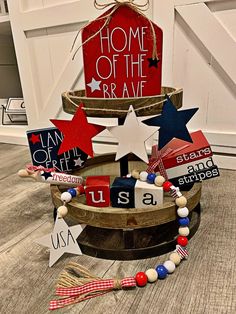 a patriotic wreath made out of wooden letters and magnets on top of a barrel