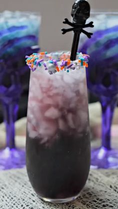 a purple drink with sprinkles and a black stick sticking out of it