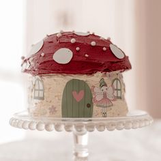 there is a cake that looks like a house with a fairy on it and a mushroom on top