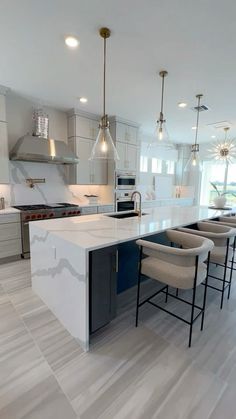 a kitchen with an island and bar stools next to the counter top in front of it