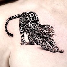 a black and white tattoo of a leopard on the back of a woman