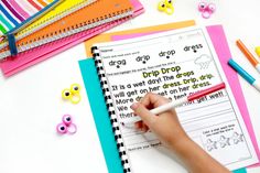 a child is writing on a clipboard with crayons and other school supplies