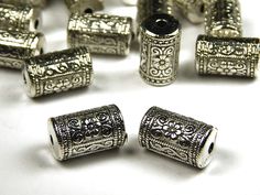 a bunch of silver colored beads on a white surface