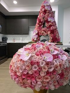 a large bouquet of pink and white flowers in the shape of a letter on top of a table