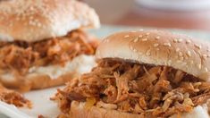 three pulled pork sandwiches on a white plate