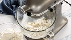 a mixer mixing ingredients in a bowl on top of a counter next to a blender