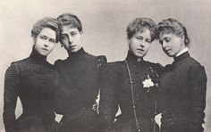 an old photo of three women standing next to each other in black dresses and pearls on their necklaces