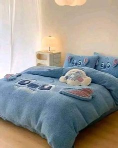 a bed with blue comforter and pillows on it