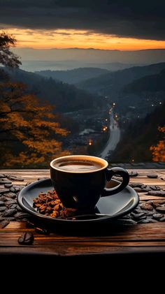 a cup of coffee sitting on top of a saucer next to a plate filled with nuts