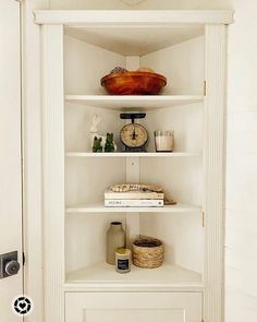 a white book shelf with books and other items on it