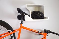 an orange bike with a helmet on it's seat and a cup holder attached to the back