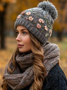 a woman with long hair wearing a gray hat and scarf in the fall, looking off into the distance