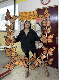 a woman standing in front of a bunch of butterflies