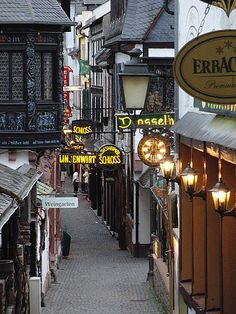 an alley way with many signs and lights on the buildings along it's sides