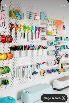 there is a wall mounted craft supply rack with scissors and other items on it,