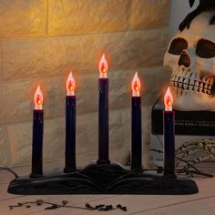 five candles are lit in front of a skull