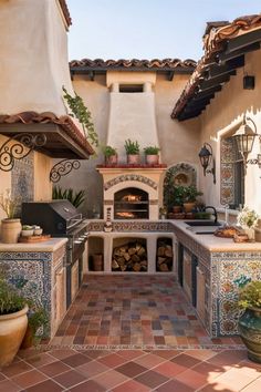 an outdoor kitchen with tile counter tops and potted plants on the outside patio area