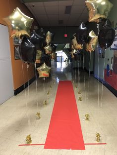 the hallway is decorated with gold and black balloons