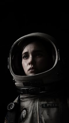 a woman in an astronaut's suit is staring into the distance