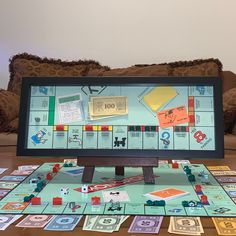 a computer monitor sitting on top of a wooden table covered in lots of different types of cards