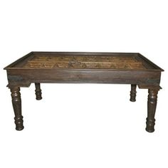 an old wooden table with carvings on the top and legs, against a white background