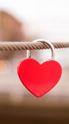 a red heart shaped padlock attached to a rope