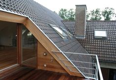 an attic with wooden flooring and metal railings on the side of a house