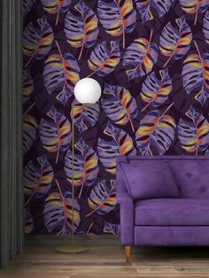 a purple couch sitting next to a lamp on top of a hard wood floor covered in wallpaper