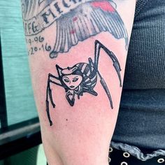 a woman's arm with a spider tattoo on it