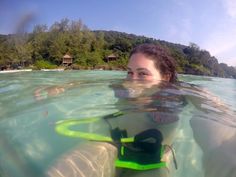 a woman swimming in the ocean with her snorkel