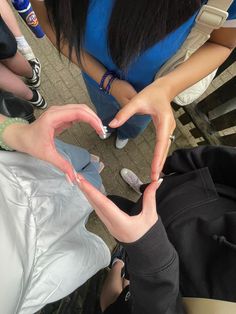 two people making a heart shape with their hands