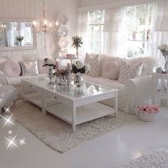 a living room filled with white furniture and lots of pillows on top of it's couches