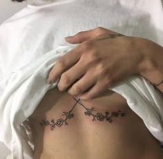 a woman's stomach with flowers on it and a hand touching the side of her belly