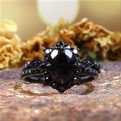 a black diamond ring sitting on top of a rock