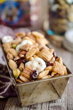 a metal container filled with cereal and nuts