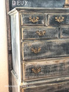 an old dresser with chalkboard on the top and writing on the bottom that says deuxx