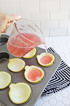 someone is pouring water into a muffin tin