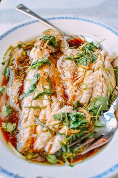 a white plate topped with fish covered in sauce