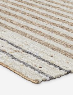 a beige and black striped rug on a white floor