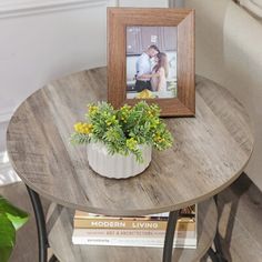 a small table with a potted plant on it and a framed photo next to it