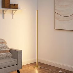 a living room with a couch, lamp and pictures on the wall