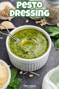 pesto dressing in a white bowl with parmesan cheese on the side